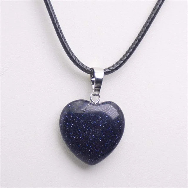 Heart-shaped blue stone pendant on a black cord against a white background