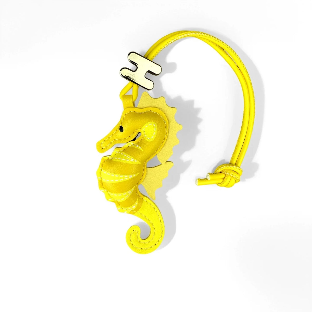 A bright yellow seahorse-shaped leather charm attached to a matching yellow adjustable cord bracelet, shown on a clean white background.