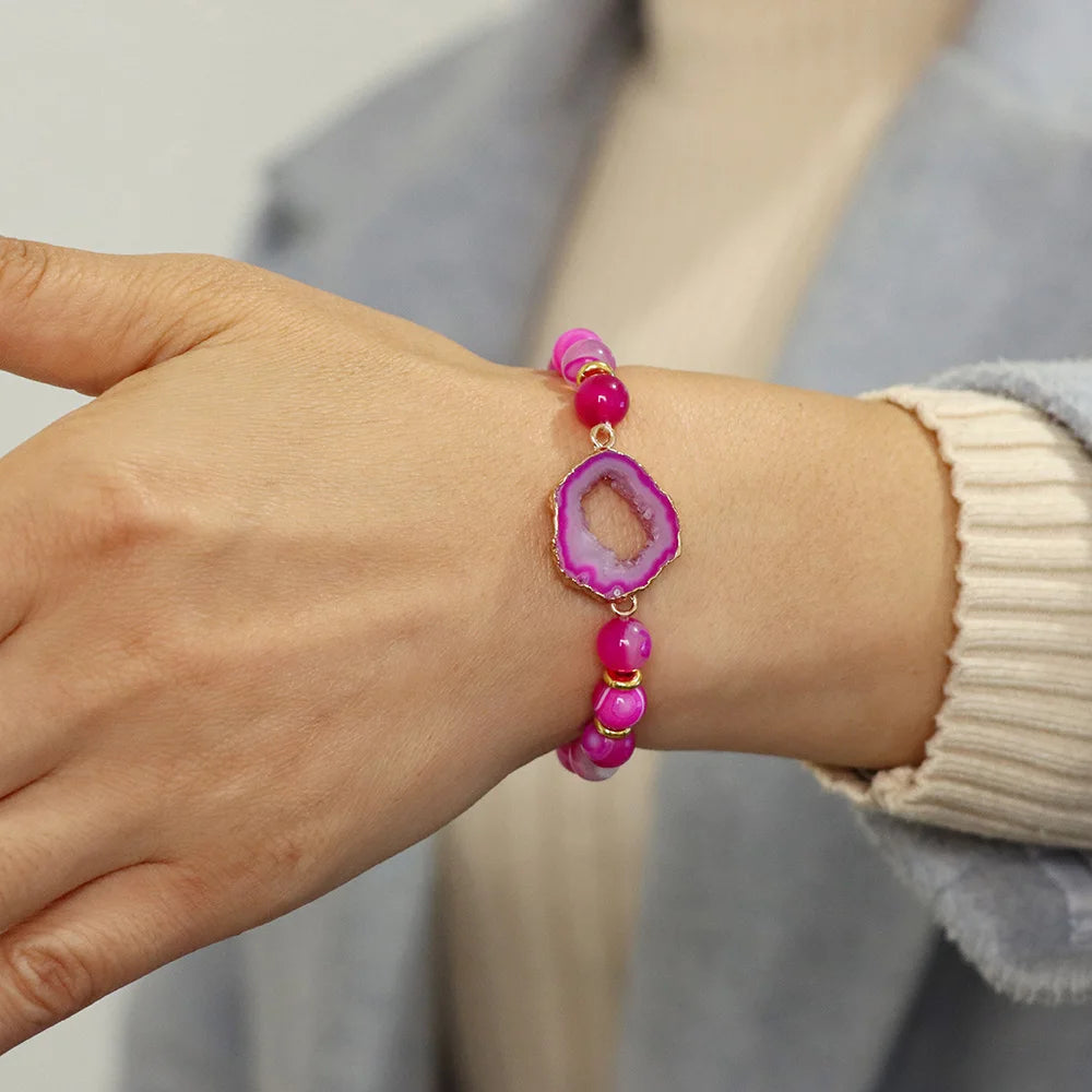 Pink beaded bracelet on a wrist with a neutral background