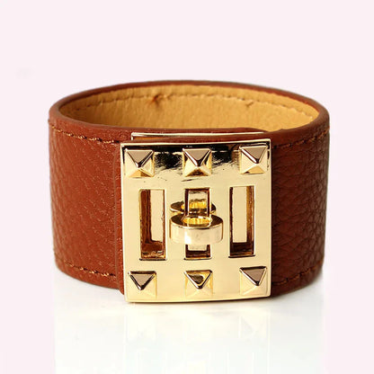 Brown leather bracelet with a gold clasp on a white background