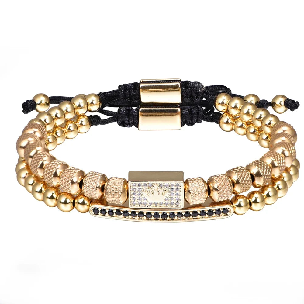 Gold beaded bracelets with black cord and gold charm on a white background