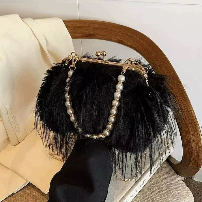 Black feathered handbag with pearl accents on a chair