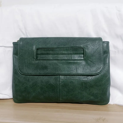 Green leather clutch bag on a white background