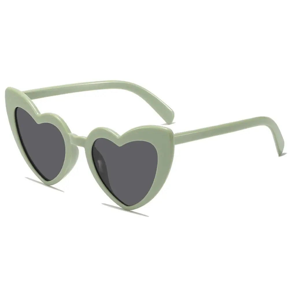 Heart-shaped sunglasses with green frame and dark lenses on a white background