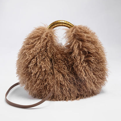 Brown fluffy handbag with a gold handle on a light grey background