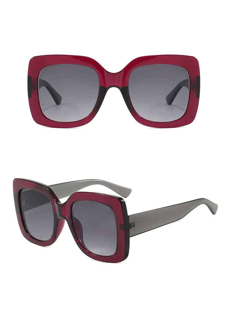 Oversized square sunglasses shown from front and side views on a white background. The frames are translucent deep red with dark grey lenses and grey temples.