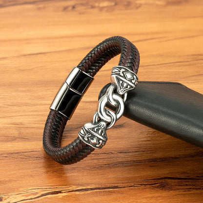 Brown leather bracelet with silver clasp on a wooden surface