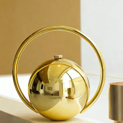 Gold decorative clutch bag with circular design on a light background