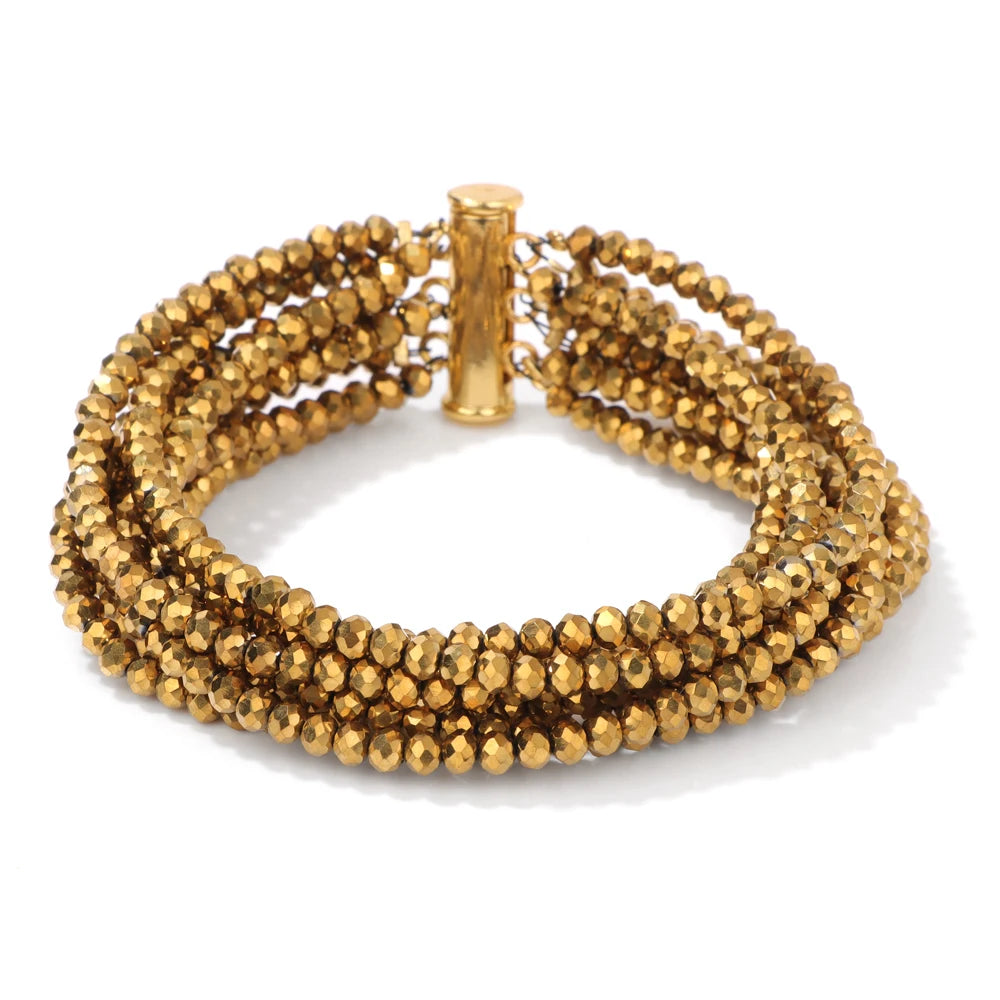 Gold beaded bracelet on a white background