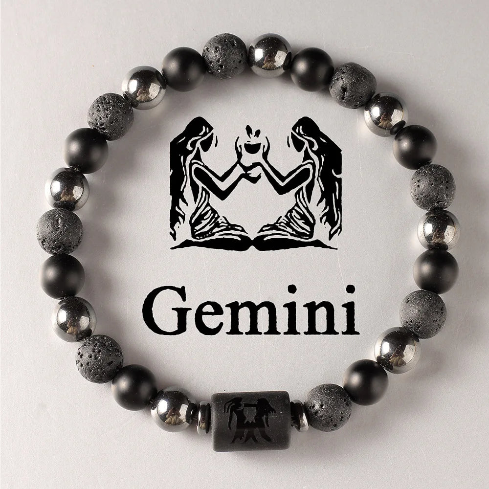 Black beaded bracelet with Gemini zodiac symbol on a light grey background
