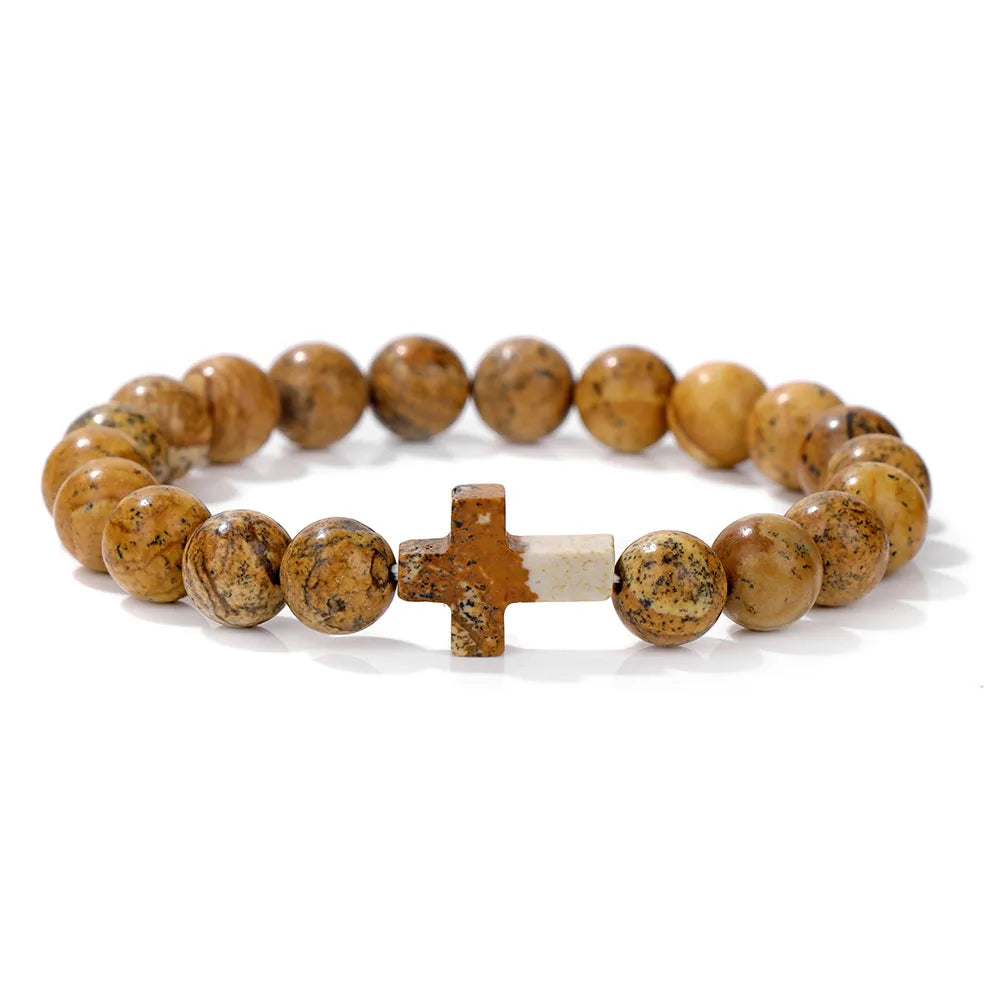 Bracelet with brown beaded stones and a cross charm on a white background