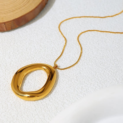 Gold necklace with a large, oval pendant on a white background