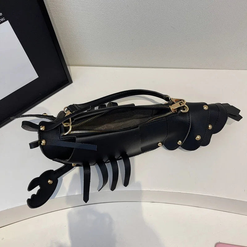 Black leather clutch with gold accents on a white surface