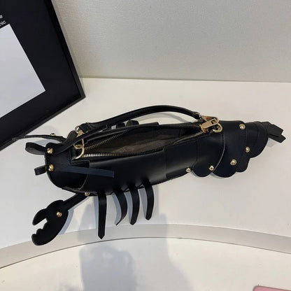 Black leather clutch with gold accents on a white surface