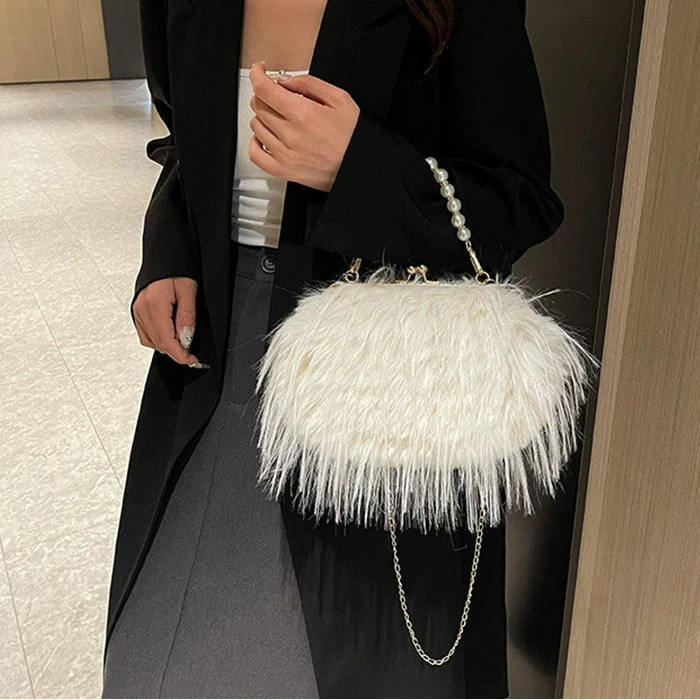 Person holding a white feathered handbag indoors