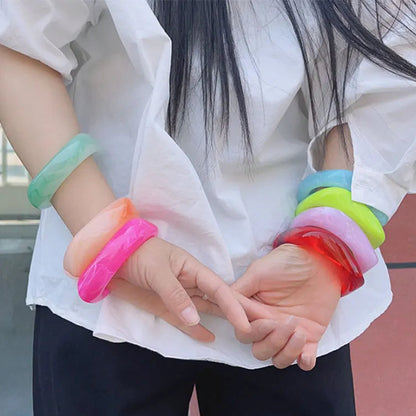 Person wearing colourful bangles on hands and wrists