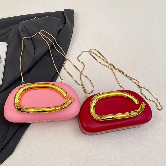 Pink and red handbags with gold handles on a light grey background