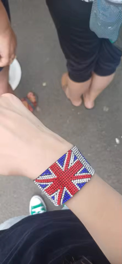 Wrist wearing a bracelet with a Union Jack design on a pavement background
