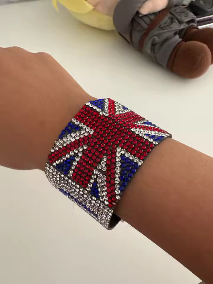 Bracelet with Union Jack design worn on a wrist, with a blurred background