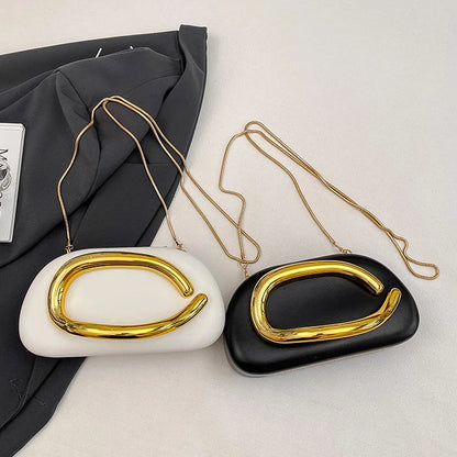 Two handbags, one white and one black, with gold clasp designs on a light grey background.